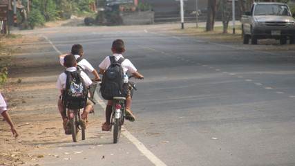 tailandia , boys leaving school by bicycle