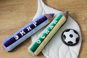 blue and green pillow pencils with names