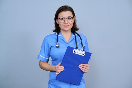 Portrait of mature nurse woman holding clipboard