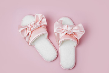 Beautiful female slippers with bow on a pink background. Flat lay, top view