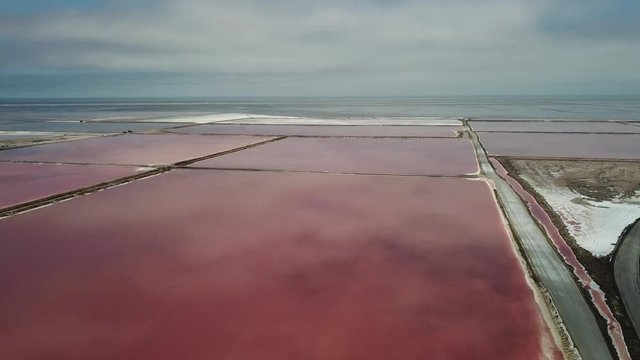 4K aerial drone video of salt works factory wide pink salty water evaporation ponds, in outskirts of coastal harbour town Walvis Bay, Namib Desert, Atlantic Ocean west coast, Namibia, southern Africa