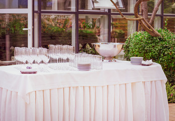 Festive table setting. Empty glasses and plates outdoors. Banquet on the terrace. Restaurant in the nature. Table setting.