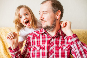 Little girl wishes dad happy father's day. Daughter hugs dad.
