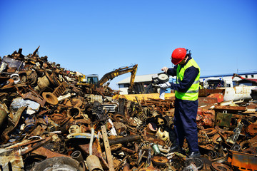 Worker on junkyard. Copy space available.