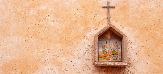 Image of an icon on the wall of a house on a city street.