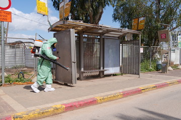 A person disinfects a bus stop from the Corona virus.
