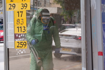 A person disinfects a bus stop from the Corona virus.
