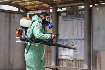A person disinfects a bus stop from the Corona virus.
