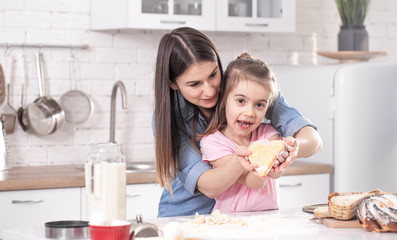 Mom and daughter prepare pastries in the kitchen.