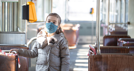 A little girl in an empty public transport during the pandemic.