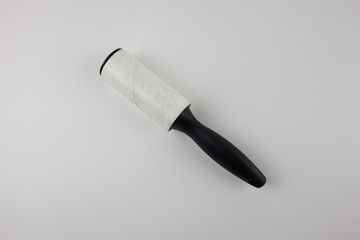Dirty sticky roller for collecting dust and hair from clothes on a white background.