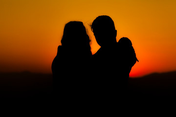 Silhouette of a womanwith a backpack in thesunset.