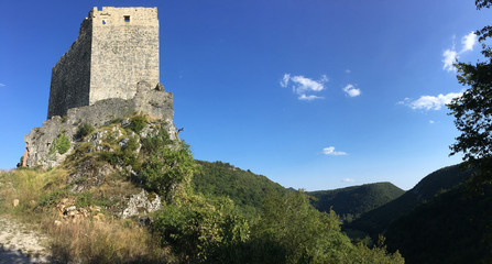 Fototapeta na wymiar An ancient castle tower of stone overlooks a lush green Vally framed by a clear blue sky in Istria Croatia. 