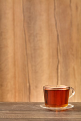 Glass cup of tea brown background. Close up.