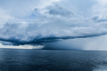Fototapeta na wymiar storm clouds over sea in a blue background. 