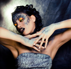 fashion portrait of pretty young woman with creative make up like a snake, halloween concept