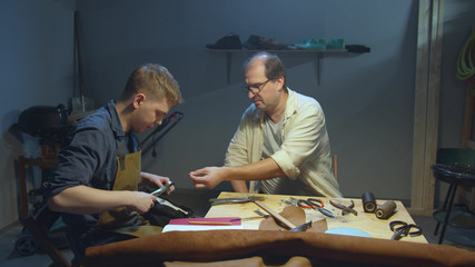Master teaches apprentice how to work with skin