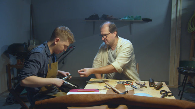 Master teaches apprentice how to work with skin