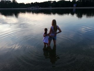 Mother and daughter enjoying together in lake water
