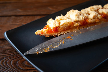 Homemade apricot pie and knife. Slice of rustic hot sweet pie. Natural organic food. Selective soft focus.