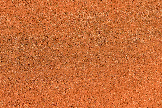 Red dry grungy clay tennis background texture. Tennis court macro