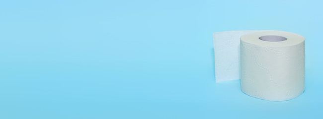 Roll of toilet paper on a blue background. Toilet paper purchase due to kronavirus concept. Cleanliness, Hygiene, Sterility, stop the spread of the virus.Banner