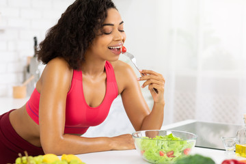 Beautiful young african girl eating vegetable salad