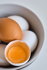 Chicken eggs on minimalist plates. Art photo with uncooked eggs on white table. Natural organic farm product. Preparing for Easter holiday. Kitchen art, dish on cuisine. Raw ingredient for cooking eat