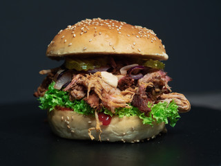 Pulled Pork Burger
Close up of a fresh handmade pulled pork burger made with fresh baked burger buns, salad, gurkin, onions and selfmade pulled pork.