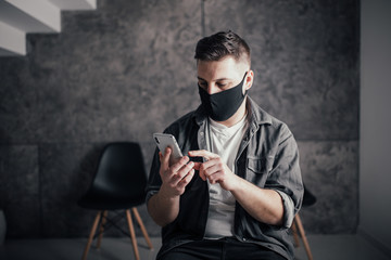 Man with back mask sitting on chair and waiting queue