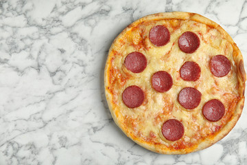 Tasty pepperoni pizza on white marble table, top view. Space for text