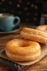 Sweet delicious glazed donuts on wooden table