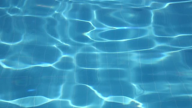 Flickering waves of clear water in the pool