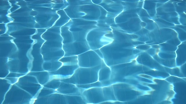 Flickering waves of clear water in the pool
