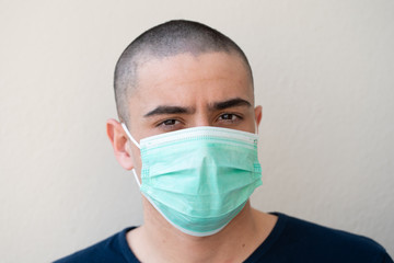 Portrait of young man, takes off the medical flu mask, on background of white color...