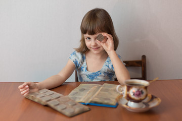 Girl numismatist plays with a coin