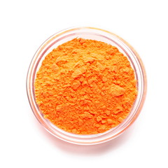 Orange powder paint in glass bowl, top view