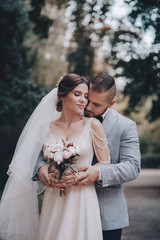 Bride and Groom at wedding Day walking Outdoors on spring nature. Bridal couple,  Loving wedding couple outdoor. 