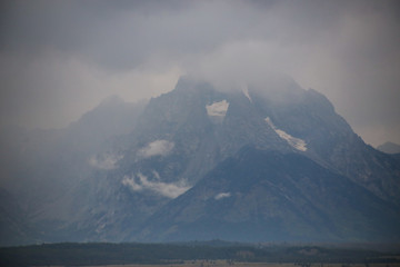 beautiful view of the  rocky mountains covered with fluffy clouds 