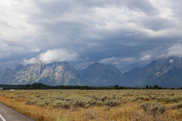 Fototapeta premium beautiful view of the rocky mountains covered with fluffy clouds 