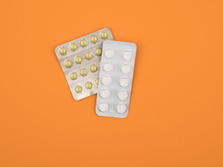 Tablets in blister packs for treatment of diseases on an orange background.