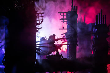 Army sniper with large caliber rifle standing in the fire and smoke. War Concept. Battle scene on...