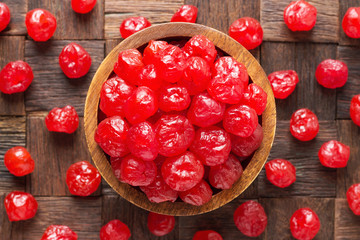 candied fruit, dried cherries with sugar in wooden bowl, top view.