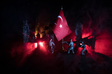 Silhouette of soldier with rifle against a turkish flag. Selective focus