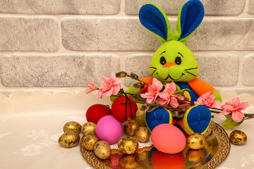 Easter bunny with twigs of pussy willows and colorful Easter eggs.