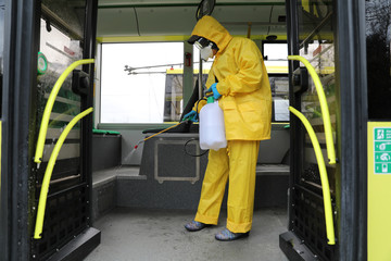 Workers disinfecting bus at bus depot. Lviv, Ukraine.