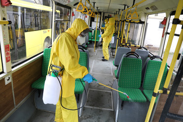 Workers disinfecting bus at bus depot. Lviv, Ukraine.