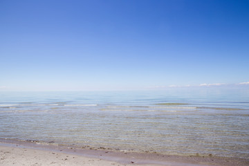 Muscheln und Steine im weißen Sand am Strand