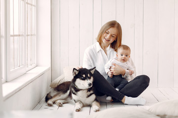 Beautiful woman with child. Woman in a white shirt. Family playing with big dog.