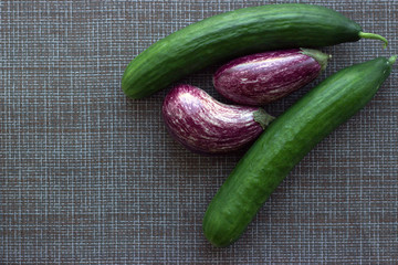 
Vegetable flatlay for vegetarians made of graffiti zucchini and long smooth cucumbers on a brown mesh napkin